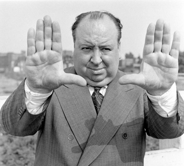 Alfred Hitchcock formant un cadre avec ses mains.